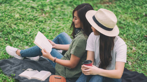 istock Two women reading book together 1177346511