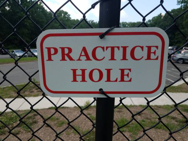 istock red and white practice hole sign on metal fencing 1177349583