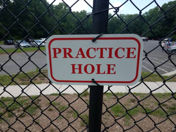 istock red and white practice hole sign on metal fencing 1177349596