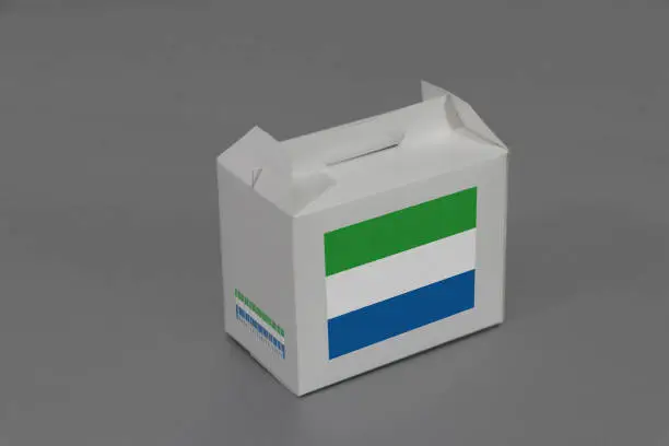 Photo of Sierra leonean flag on white box with barcode and the color of nation flag on grey background. The concept of export trading from Sierra leone.