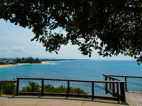 Beautiful day at Moffat Beach near Caloundra on the Sunshine Coast, Queensland, Australia, with bright blue ocean waves and green trees, seen from O'Donnell Walkway cliff walking track