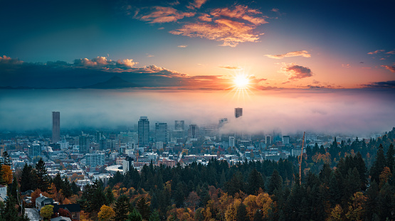 A photograph of Portland downtown with rolling fog and autumn foliage in shining sunrise and colorful clouds
