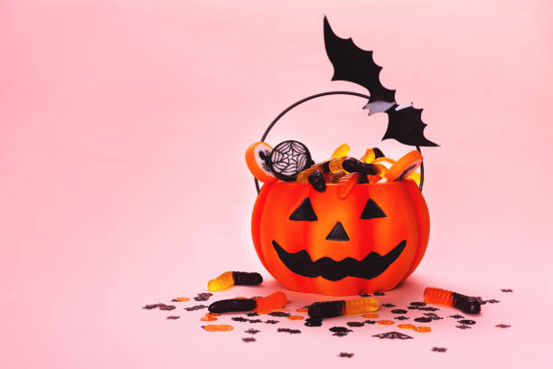 istock Halloween background made with pumpkin basket, sweets and bat. 1177360906