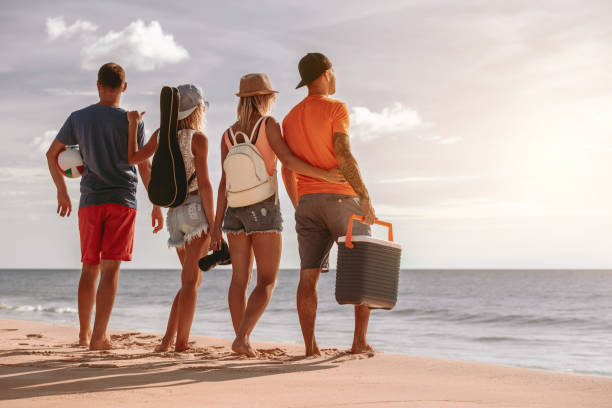 istock Four friends at sunset picnic on the beach 1177361108