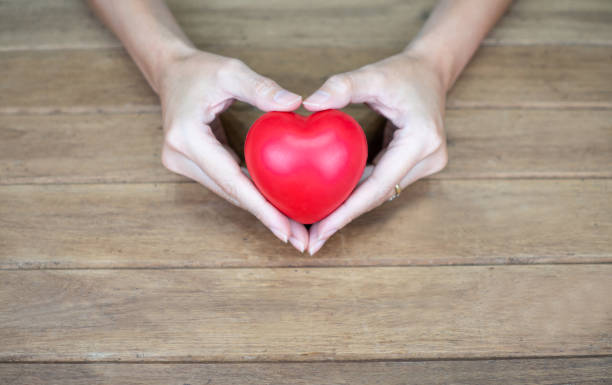 istock Hand holding heart shape on wooden background 1177362709