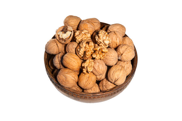 istock walnuts in wooden bowl on white background 1177363958