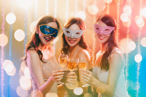 istock happy young group celebrating New Year and drinking champagne on masquerade party 1177365948