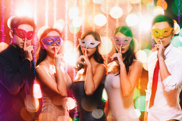 istock young group celebrating New Year on masquerade party 1177366491