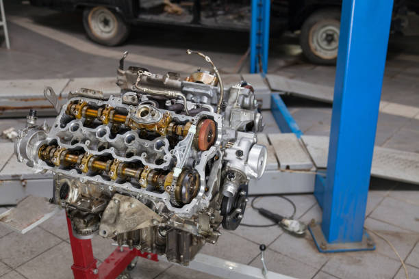 istock Used v8 engine mounted on a crane for installation on a car after a breakdown and renew in a vehicle repair workshop as a guarantee for the dealership. Auto service industry. 1177368948