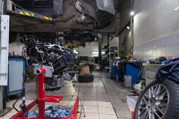 istock Replacement used engine mounted on a crane for installation on a car after a breakdown and repair in a car repair workshop as a guarantee for the dealership. Auto service industry. 1177369337