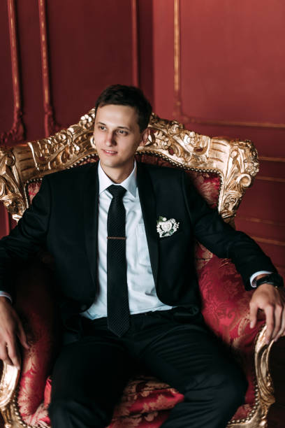 istock Groom in a suit holding buttonhole 1177369372