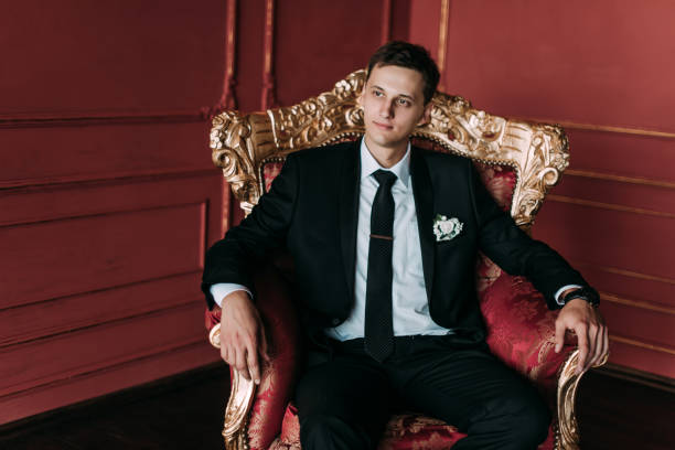 istock Groom in a suit holding buttonhole 1177369375