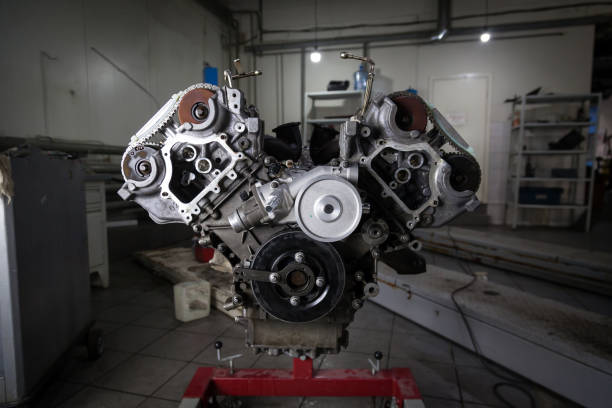 istock Replacement used engine mounted on a crane for installation on a car after a breakdown and repair in a car repair workshop as a guarantee for the dealership. Auto service industry. 1177369657