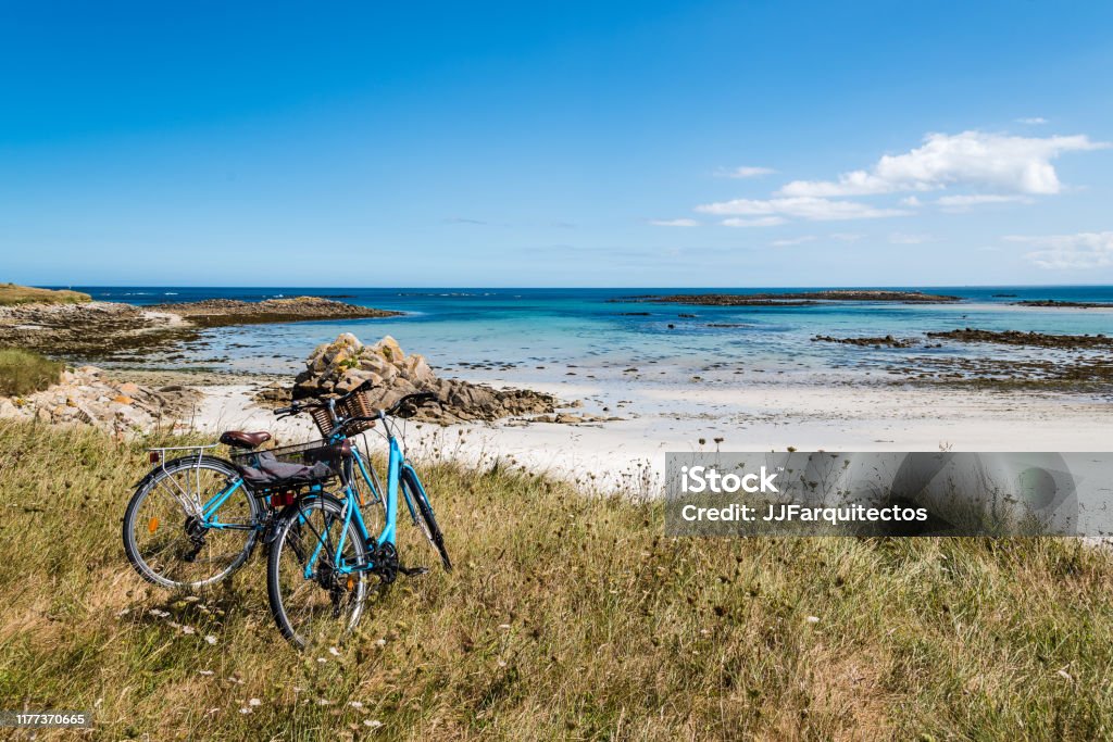 Bicycle parked against the sea in the island of Batz Bicycles parked against the beach in the island of Batz with no people. Summer adventure Bicycle Stock Photo