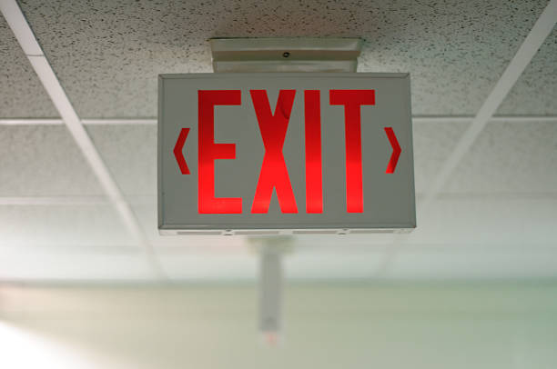 An exit sign hanging from a ceiling stock photo