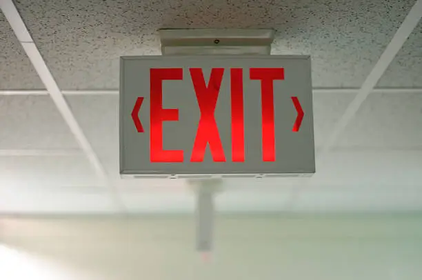 Photo of An exit sign hanging from a ceiling