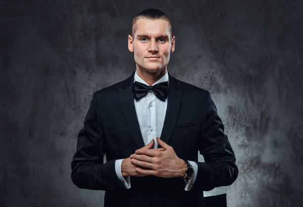 istock Successful elegantly dressed man wearing a black classical suit and bow tie, looking at a camera. 1177372293