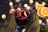 Woman holding a glass cup of hot Christmas mulled wine in hands, closeup.