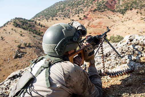 Soldier saluting at sunset and twillight with his rifle