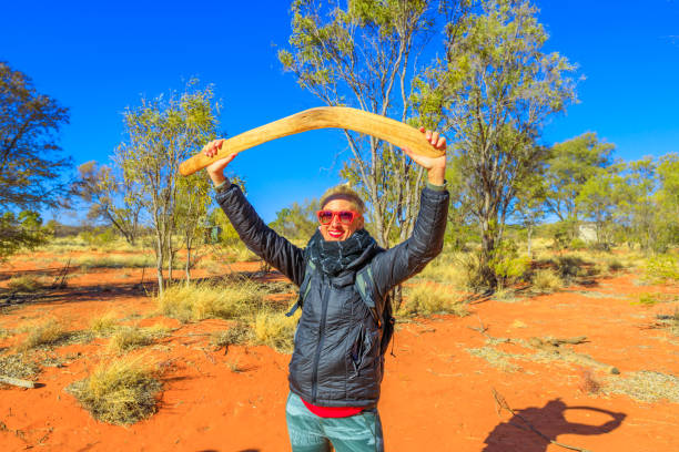 frau mit aborigine-boomerang - australia boomerang aboriginal aborigine stock-fotos und bilder