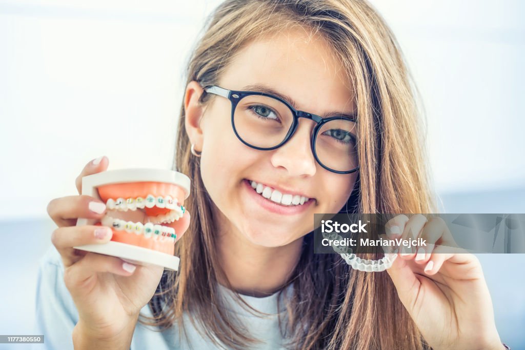 Dental unsichtbare Zahnspangen oder Silikon-Trainer in den Händen eines jungen lächelnden Mädchen. Kieferorthopädisches Konzept - Invisalign. - Lizenzfrei Zahnspange Stock-Foto