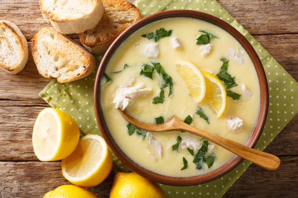 Thick aromatic Greek lemon soup with chicken and orzo paste close-up in a bowl on the table. Horizontal top view from above