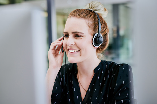 How can I help you? Beautiful call center workers in headphones are working at modern office.