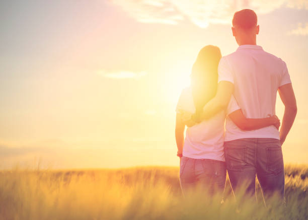 istock Back view of affectionate young couple stand closely, admire nature, see something into distance, enjoy sunset, copy space aside 1177387225