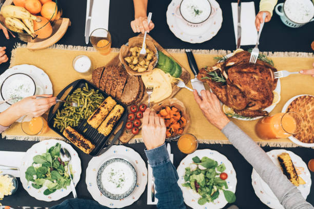 Overhead view of table during Christmas dinner Overhead view of big family eating from table during Christmas dinner dining table stock pictures, royalty-free photos & images