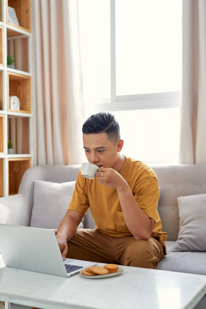 istock happy young Man sitting in sofa and using laptop 1177388210