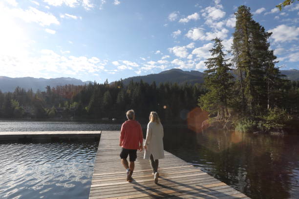 Couple walk along lakeside pier