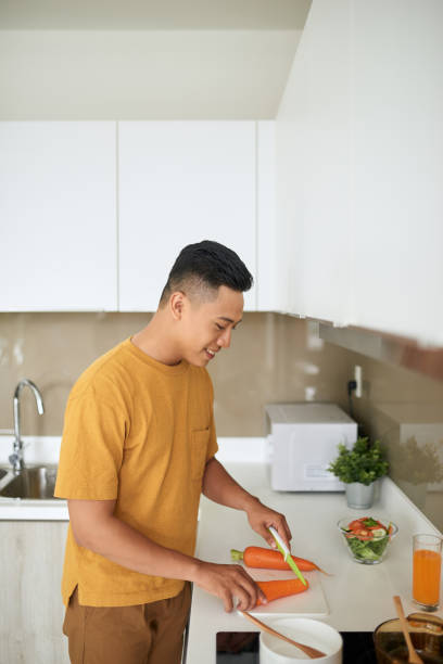 istock happy young man cutting vegetables in kitchen 1177388479