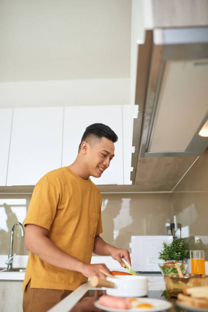 istock happy young man cutting vegetables in kitchen 1177388792