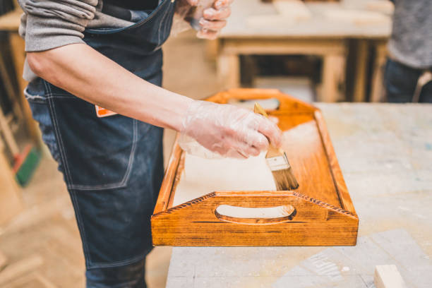 istock Manual processing of wood in carpentry workshop - applying varnish on the product 1177389352