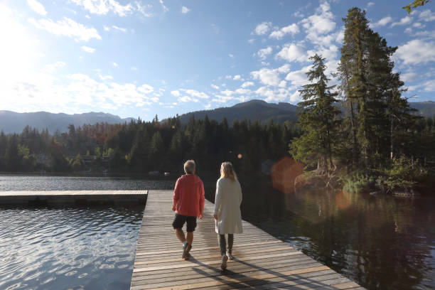 istock Couple walk along lakeside pier 1177389976