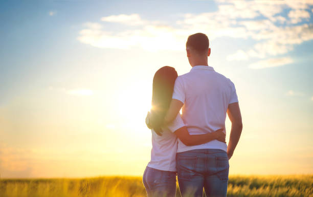 istock Back view of affectionate young couple stand closely, admire nature, see something into distance, enjoy sunset, copy space aside 1177390422