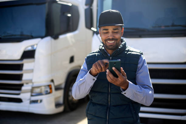Truck driver using a mobile app stock photo