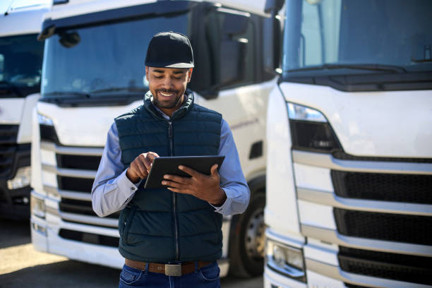 truck driver using a tablet - transportation freight transportation messenger delivering imagens e fotografias de stock