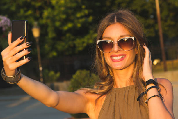 istock Woman with sunglasses taking a selfie 1177392441