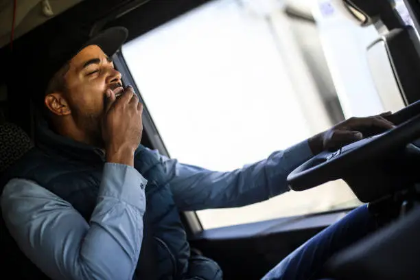 Truck driver yawning. About 35 years old, African male.