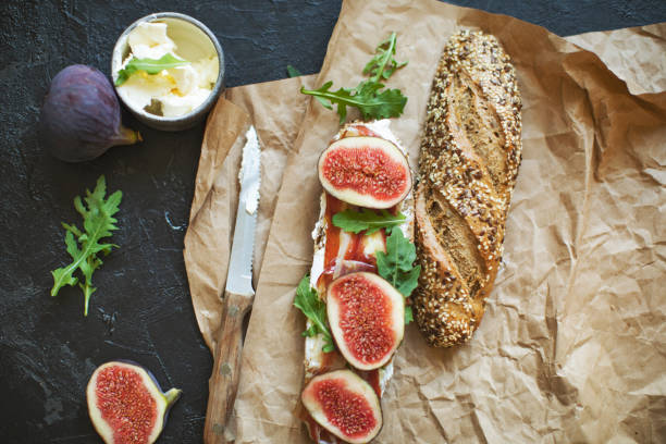 Healthy sandwich with bread, cream cheese, prosciutto, figs