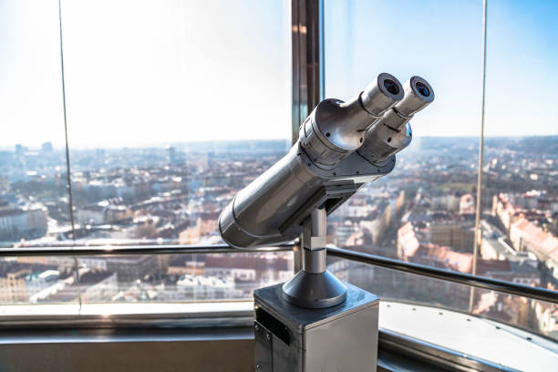 Close up telescope on observation deck aimed at city center landscape