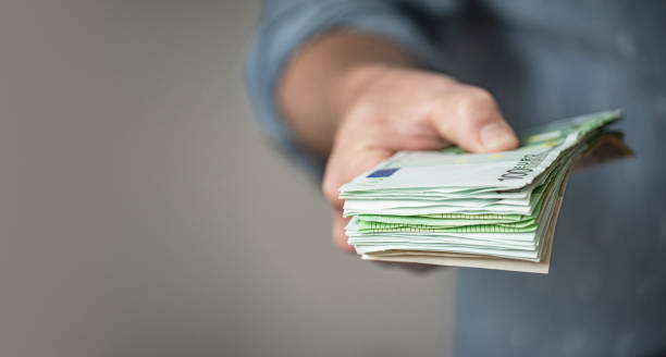 istock Man gives a stack of euro banknotes 1177394521