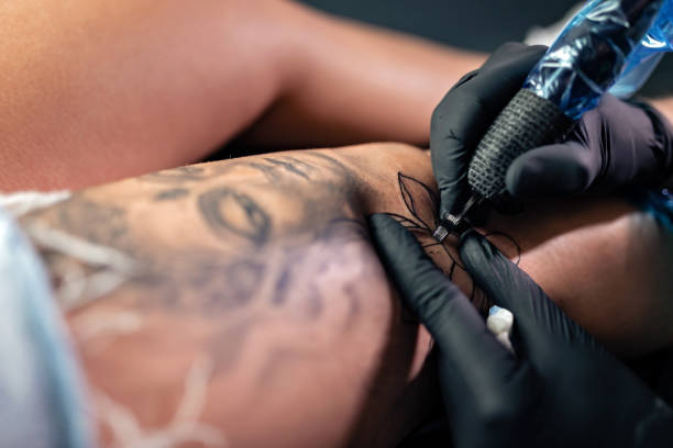 istock Tattooist doing tattoo on woman leg 1177397165