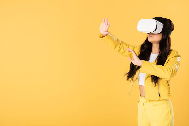 istock beautiful emotional girl using Virtual reality headset, Isolated On yellow 1177399096