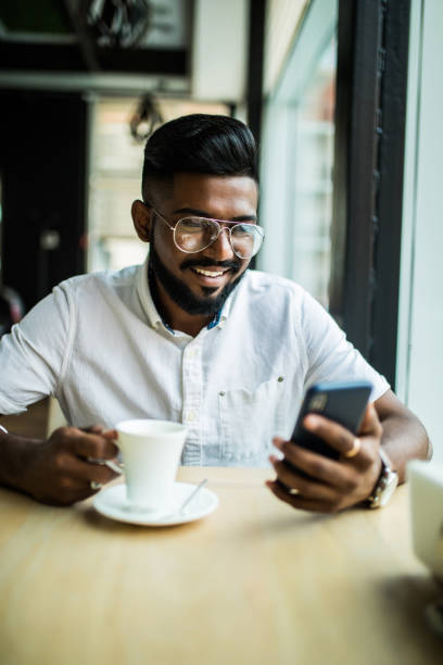 istock Indian man with smartphone in a coffee shop 1177401261