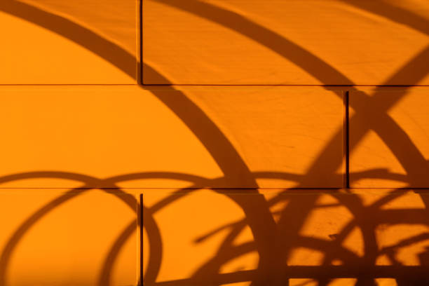fuzzy blurry curved shadow on the orange wall. abstract shadow drawing on the wall in summer at the end day. - orange wall imagens e fotografias de stock