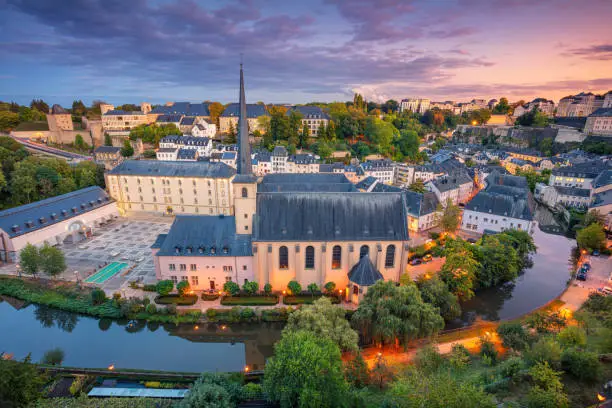 Aerial cityscape image of old town Luxembourg City skyline during beautiful sunset.