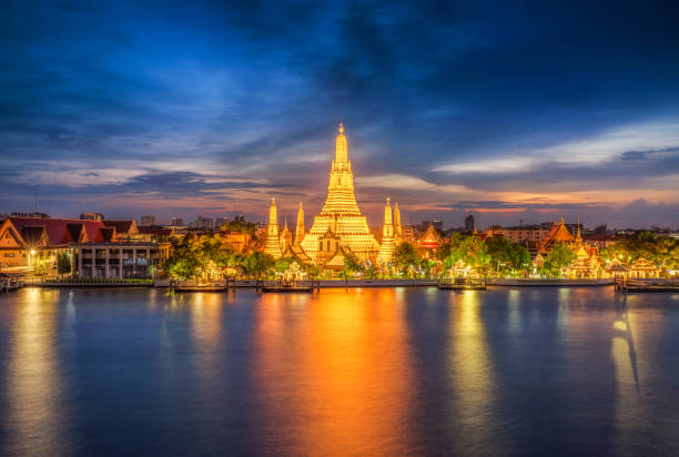 lo skyline della città al tramonto del tempio di wat arun e del fiume chao phraya, bangkok. thailandia - bangkok thailand skyline night foto e immagini stock