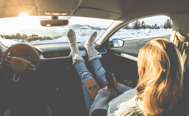 Woman using smartphone inside car with feet warm socks on dashboard - Girl relaxing in auto trip reading travel book with snow mountains in background - Traveler concept - Focus on feet Woman using smartphone inside car with feet warm socks on dashboard - Girl relaxing in auto trip reading travel book with snow mountains in background - Traveler concept - Focus on feet aspen colorado photos stock pictures, royalty-free photos & images